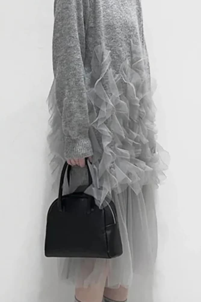 A grey knit reworked with ruffled grey tulle, worn with a black handbag